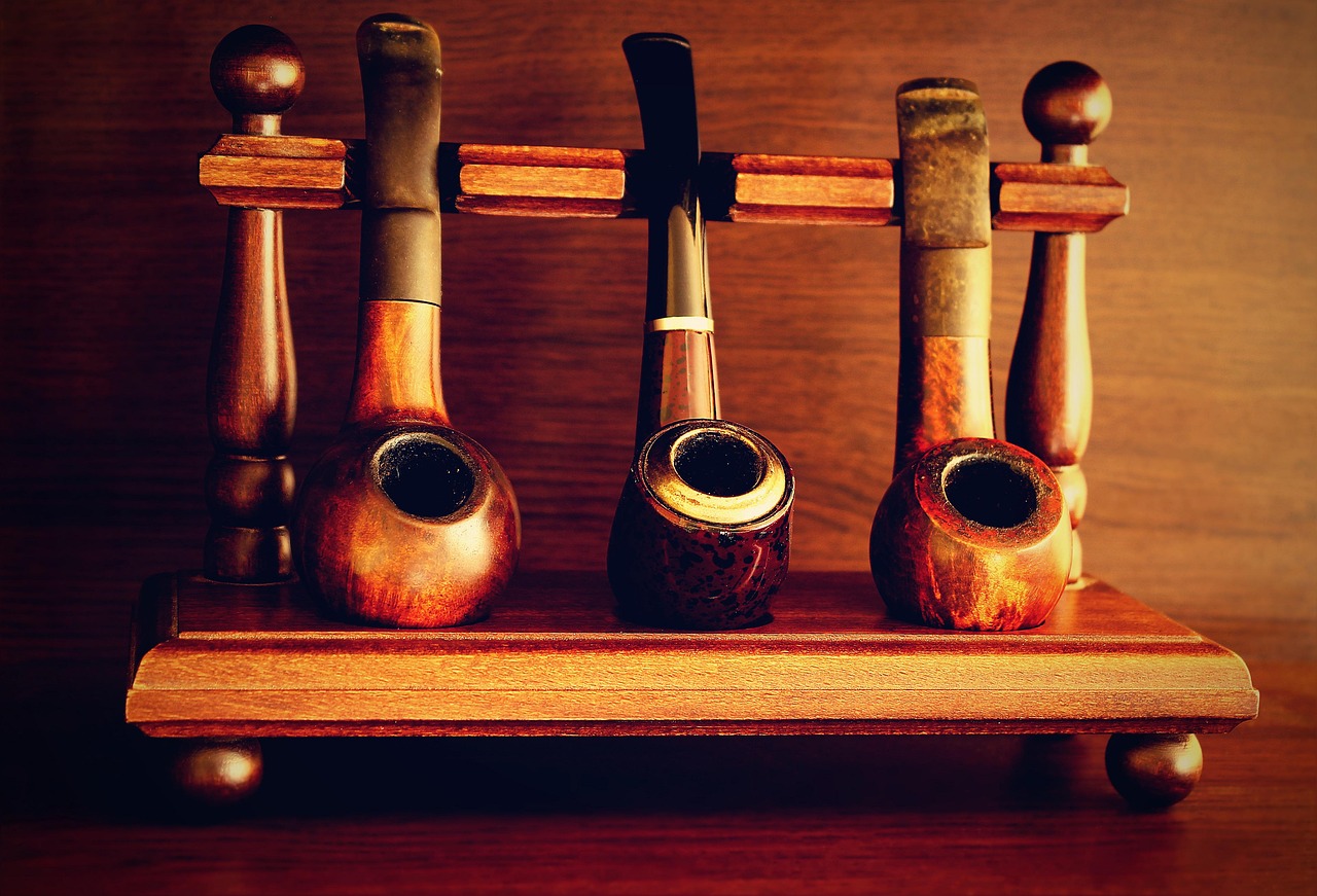 Des pipes à tabac anciennes en bois rangées sur un présentoir